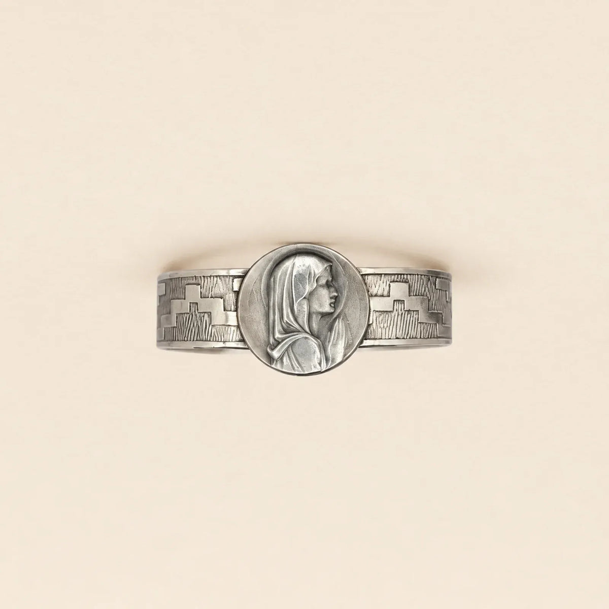 Brazalete plateado con figura religiosa