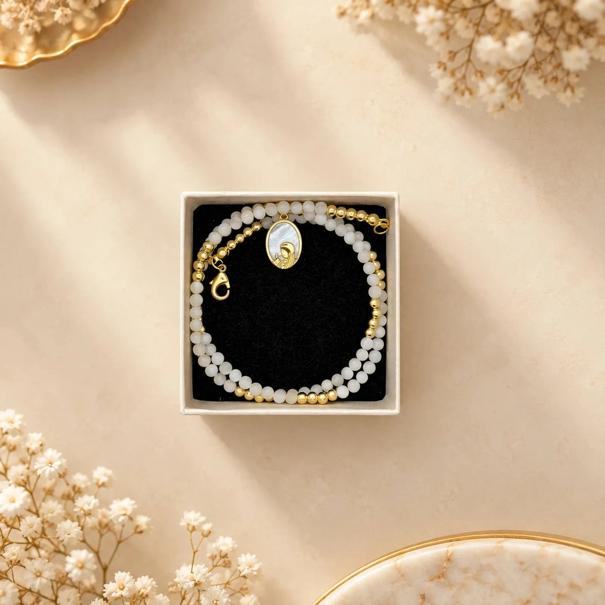 Collar de cuentas de nácar con medallón ovalado dorado