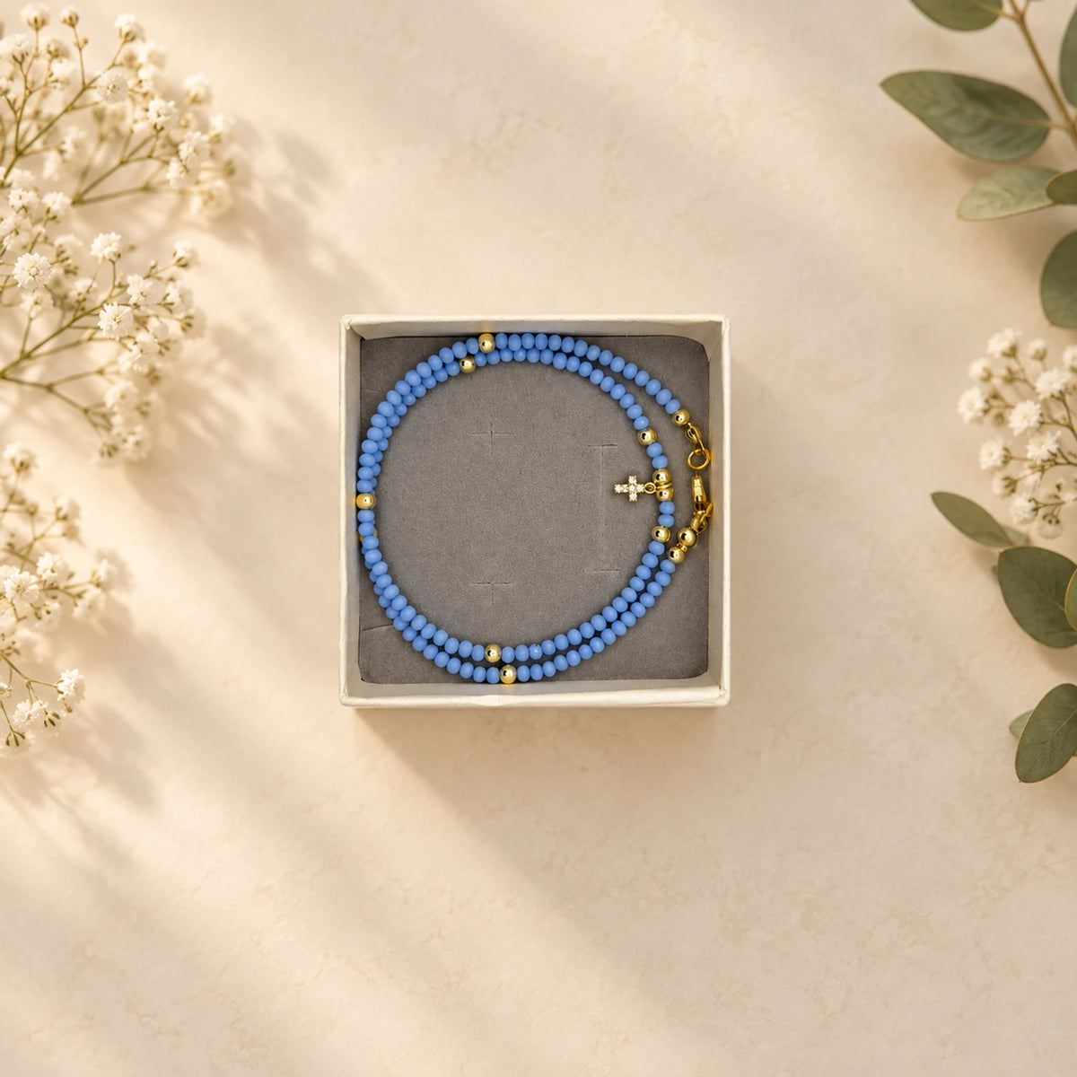 Collar de cuentas azul con dije de cruz dorada