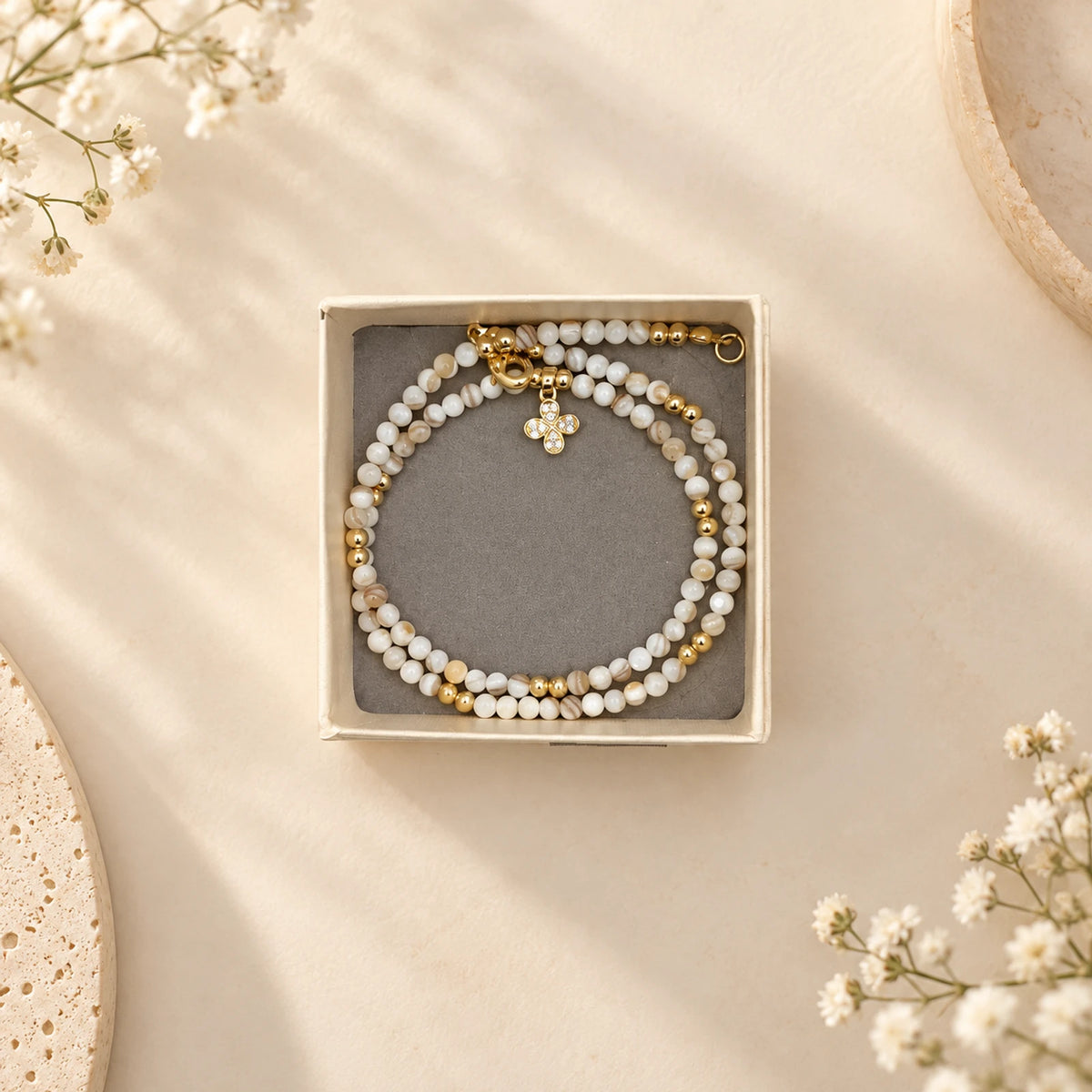 Collar de cuentas de nácar con dije de trébol dorado