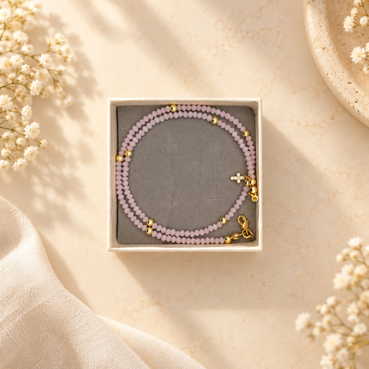 Pulsera de cuentas rosa y lila con dije de cruz dorada